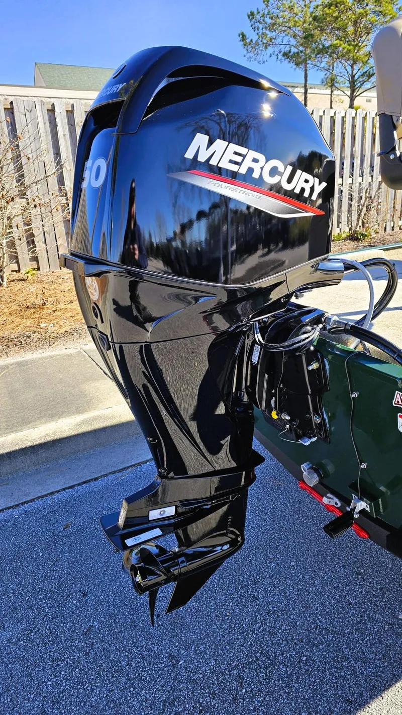 Slide: The Image of 2025 Tracker Bass Tracker Classic Limited with Mercury outboard motor, parked outdoors. - 8