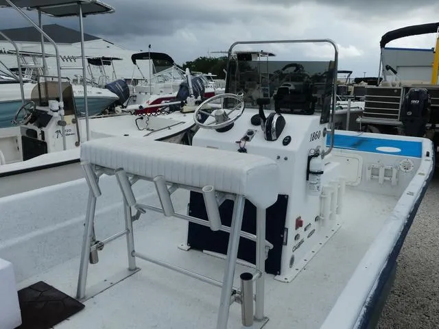 Slide: The Image of 2008 KenCraft Boats 1860 SKIFF, white interior, docked among other boats, overcast sky. - 6