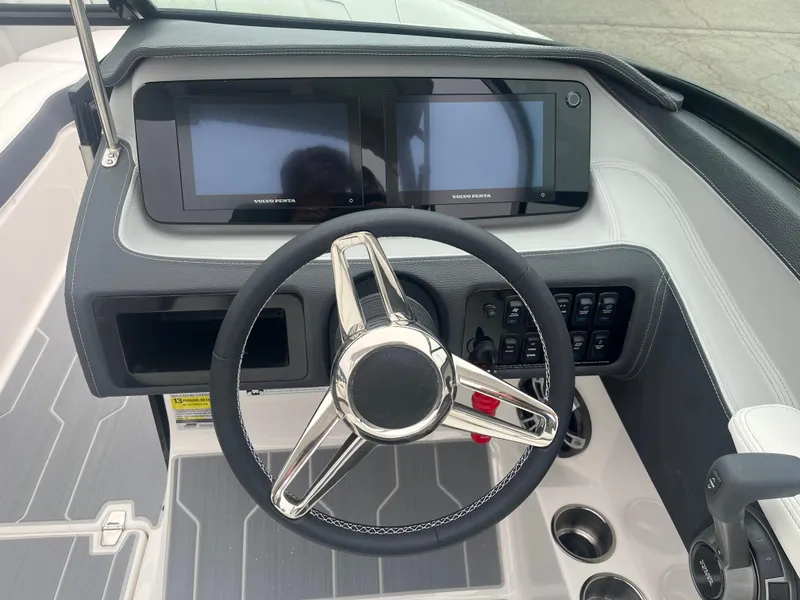 Slide: The Image of 2025 Regal LS4 Surf boat dashboard with dual screens and modern steering wheel. - 12