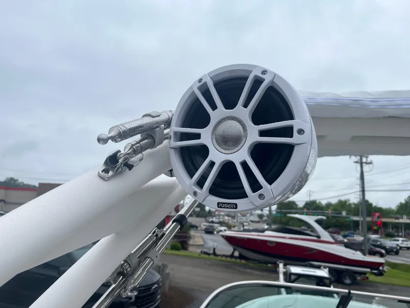 Slide: The Image of 2025 Regal LS4 Surf boat with mounted audio speaker on a cloudy day. - 20