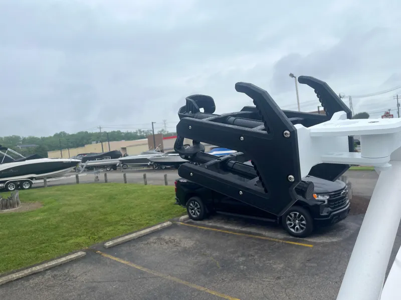 Slide: The Image of 2025 Regal LS4 Surf boat on trailer in parking lot, overcast sky. - 5