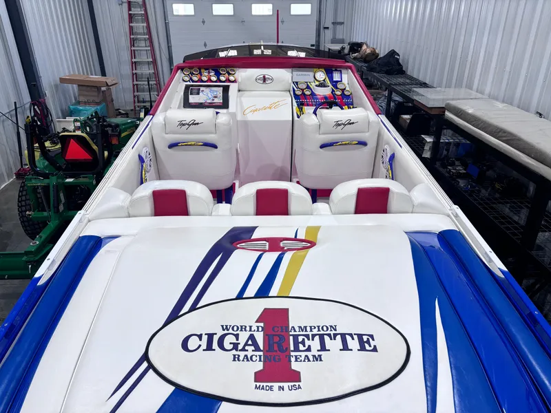 Slide: The Image of 2004 Cigarette 38 Top Gun boat interior with racing team branding in a garage. - 16