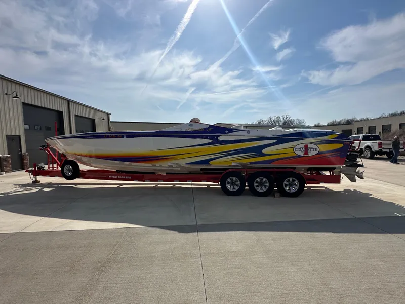 Slide: The Image of 2004 Cigarette 38 Top Gun boat on trailer, vibrant colors, parked outdoors. - 27