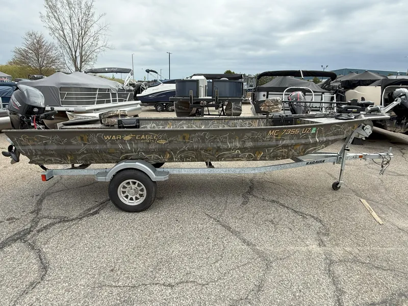 Slide: The Image of 2024 War Eagle 754LDV Sportsman boat on trailer in parking lot. - 1
