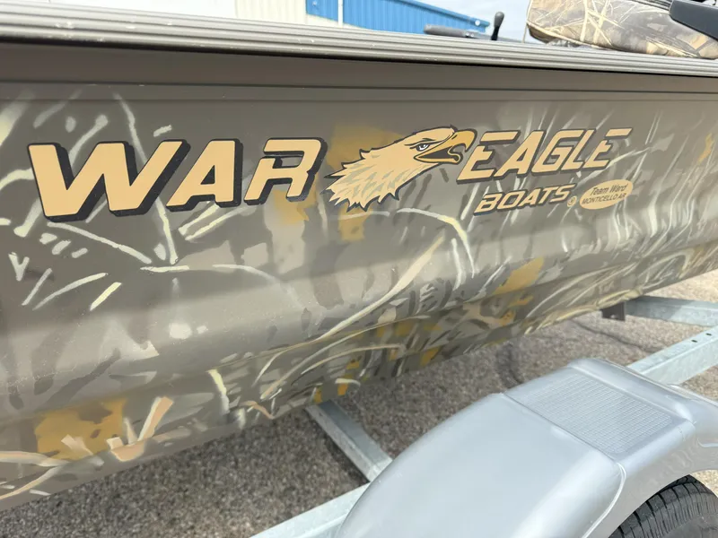 Slide: The Image of 2024 War Eagle 754LDV Sportsman boat with camouflage design and logo on trailer. - 15