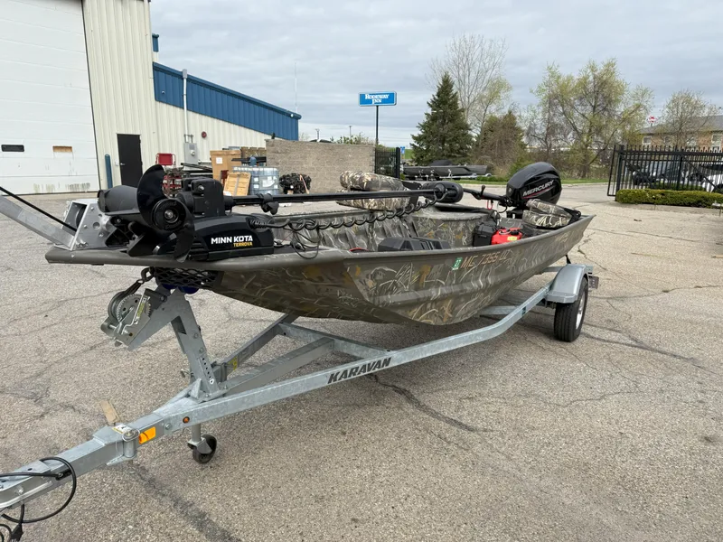 Slide: The Image of 2024 War Eagle 754LDV Sportsman boat on trailer, parked outdoors. - 2