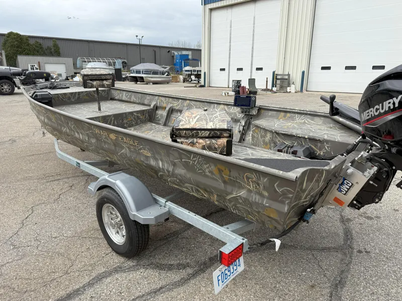Slide: The Image of 2024 War Eagle 754LDV Sportsman boat on trailer, parked outside a warehouse. - 4