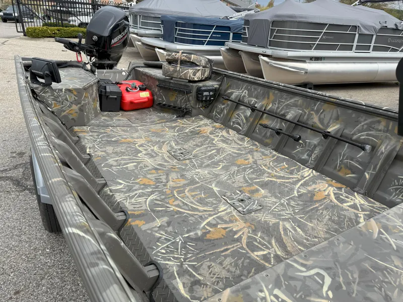 Slide: The Image of 2024 War Eagle 754LDV Sportsman boat with camouflage interior, outboard motor, and fuel tank. - 6