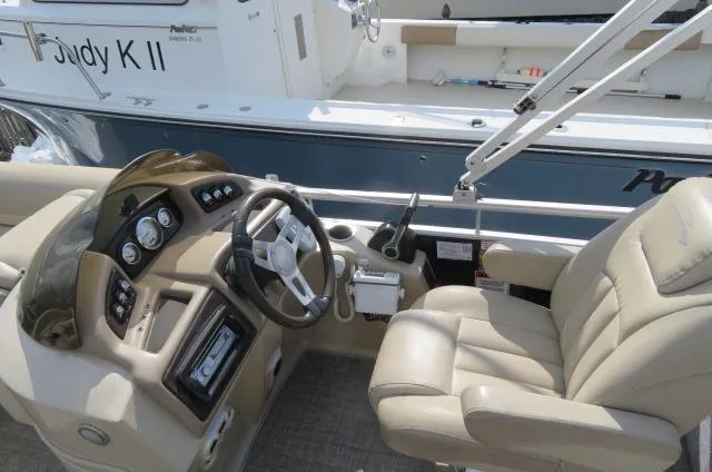 Slide: The Image of 2014 Bennington 2275 GCW boat interior with steering wheel and beige captain's chair. - 13