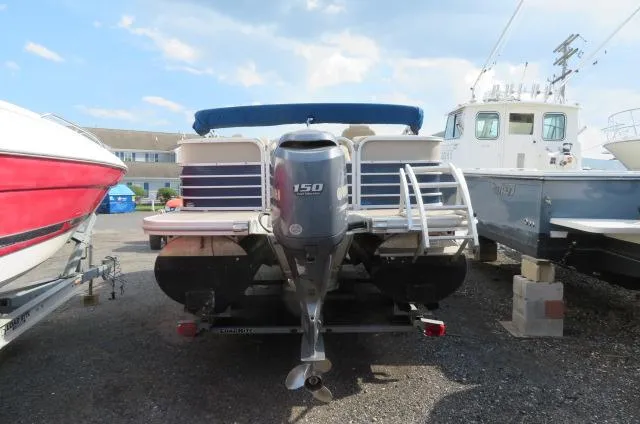 Slide: The Image of 2014 Bennington 2275 GCW pontoon boat with 150 HP engine, parked outdoors. - 2