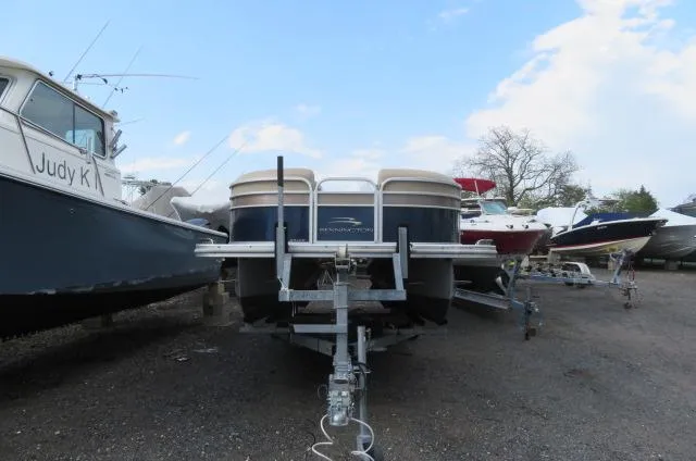 Slide: The Image of 2014 Bennington 2275 GCW pontoon boat on trailer, surrounded by other boats in a yard. - 20