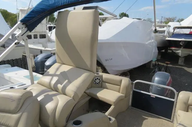 Slide: The Image of 2014 Bennington 2275 GCW boat with beige seating and covered boats in the background. - 9