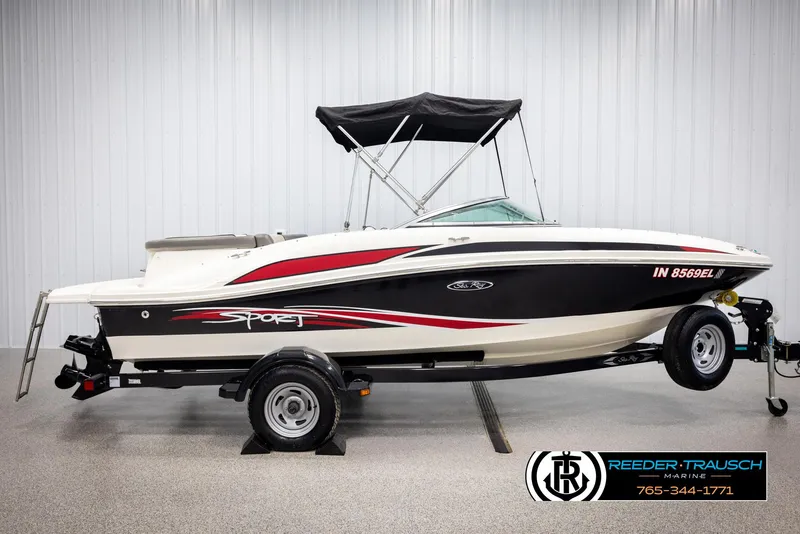 Slide: The Image of 2011 Sea Ray 185 Sport boat with trailer, black and red accents, displayed indoors. - 5