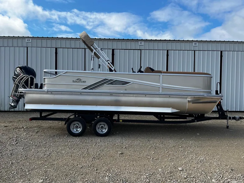 The Image of 2025 SunCatcher Fusion 324SL pontoon boat on trailer, parked outdoors. - 0