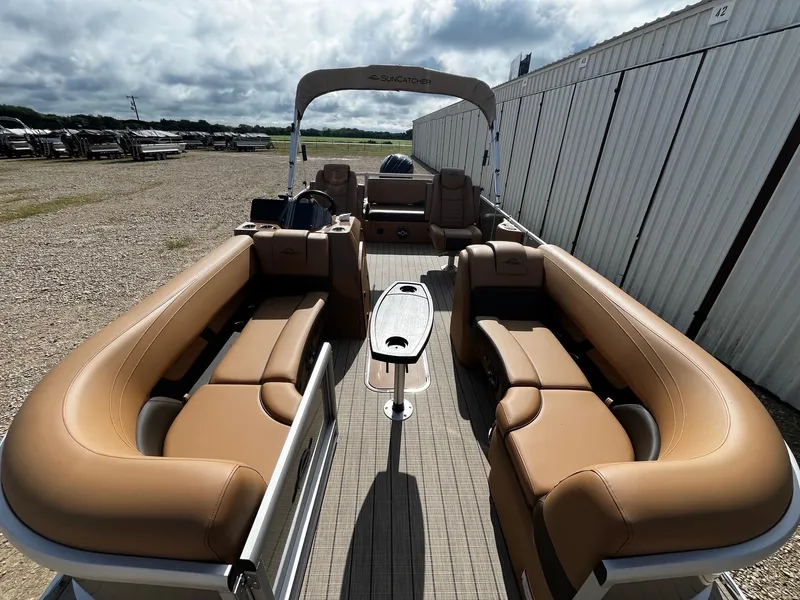 Slide: The Image of 2025 SunCatcher Fusion 324SL pontoon boat with tan seating and central table. - 10