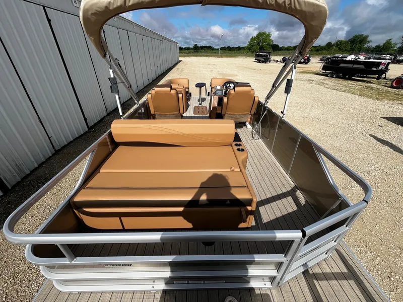 Slide: The Image of 2025 SunCatcher Fusion 324SL pontoon boat with tan seating, docked outdoors. - 12