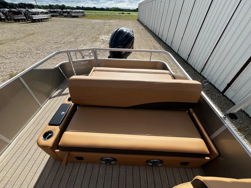 Slide: The Image of 2025 SunCatcher Fusion 324SL boat with tan seating and sleek design, docked outdoors. - 13