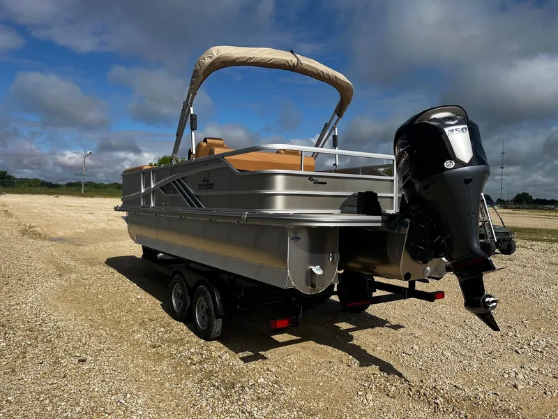 Slide: The Image of 2025 SunCatcher Fusion 324SL pontoon boat on trailer, parked on gravel under cloudy sky. - 5