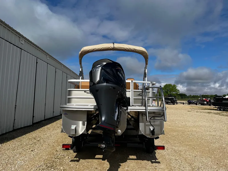 Slide: The Image of 2025 SunCatcher Fusion 324SL pontoon boat with outboard motor, parked outdoors. - 6
