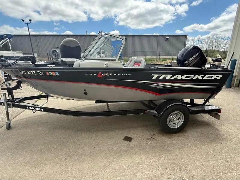 Slide: The Image of 2014 Tracker Pro Guide V-175 WT boat on trailer, parked outdoors under cloudy sky. - 2