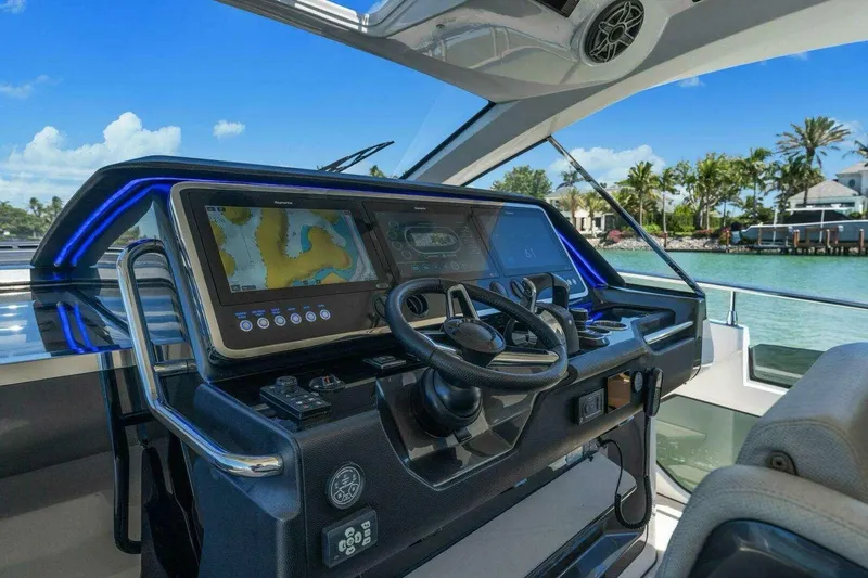 Slide: The Image of 2022 Azimut Verve 47 yacht helm with advanced navigation system and scenic waterfront view. - 6