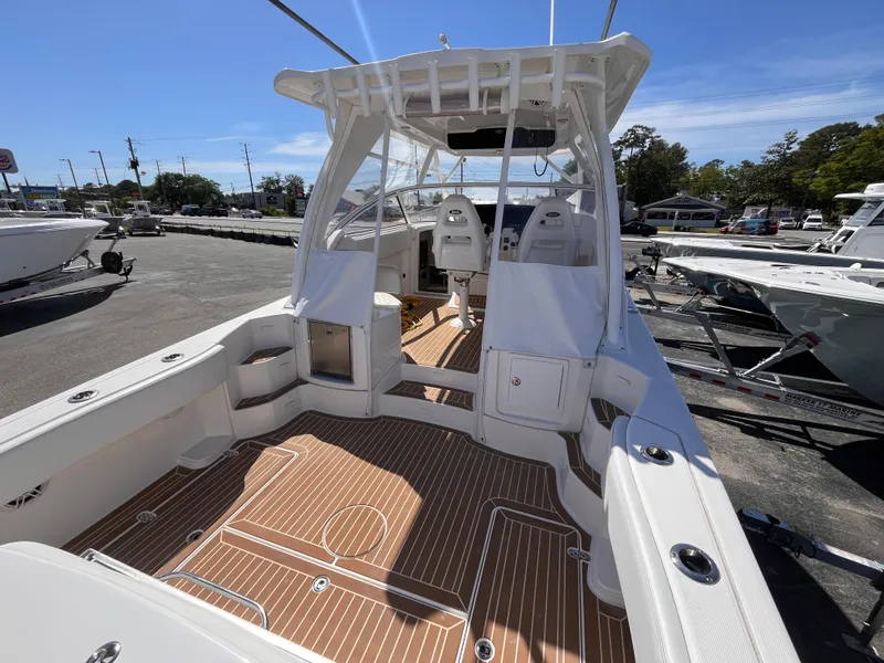 Slide: The Image of 2021 Fountain 38 SFC boat with spacious deck and modern design in a marina setting. - 24