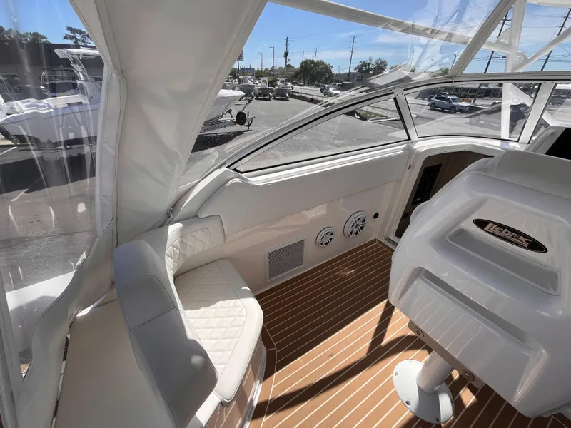 Slide: The Image of 2021 Fountain 38 SFC boat interior with white seating and wood-patterned flooring. - 28