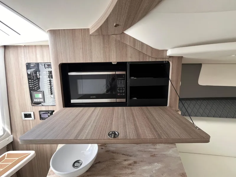 Slide: The Image of 2021 Fountain 38 SFC interior with microwave, wooden cabinetry, and modern design elements. - 41