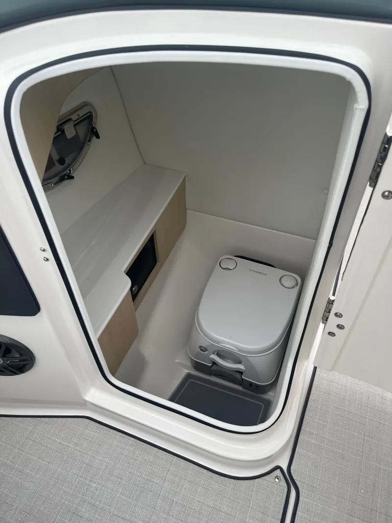 Slide: The Image of 2025 Regal LS6 boat interior with compact marine toilet and storage. - 12