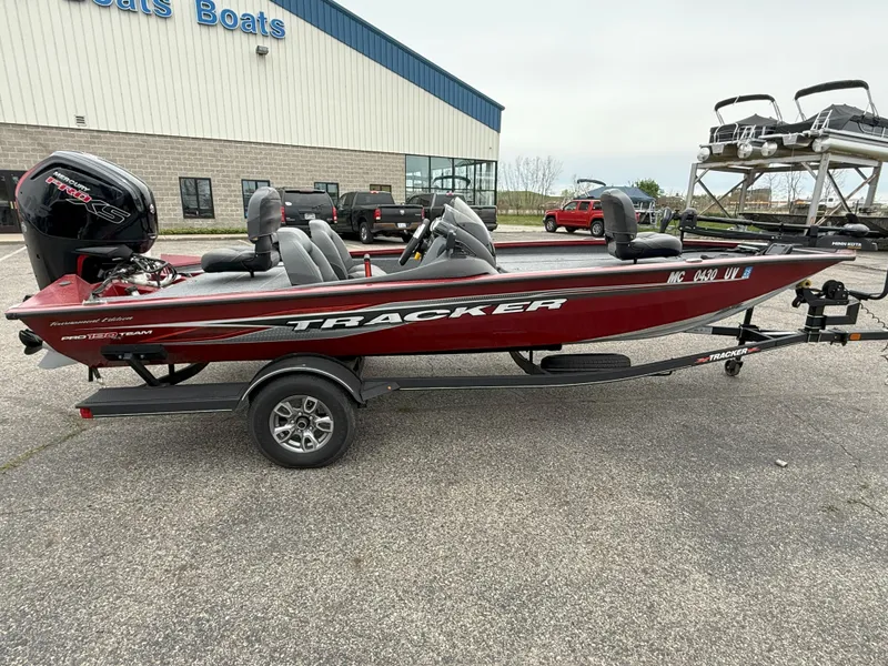 Slide: The Image of 2022 Tracker Pro Team 190 TX boat on trailer, parked outside a building. - 2