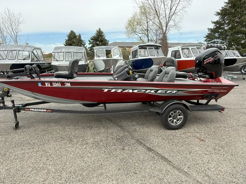 Slide: The Image of 2022 Tracker Pro Team 190 TX boat on trailer, parked outdoors with other boats. - 4