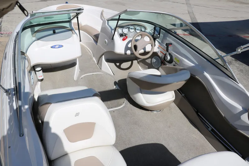 Slide: The Image of 2006 Four Winns 180 Horizon boat interior with beige and white seating, steering wheel, and dashboard. - 12