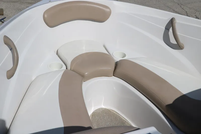Slide: The Image of 2006 Four Winns 180 Horizon boat interior with beige seating and cup holders. - 18