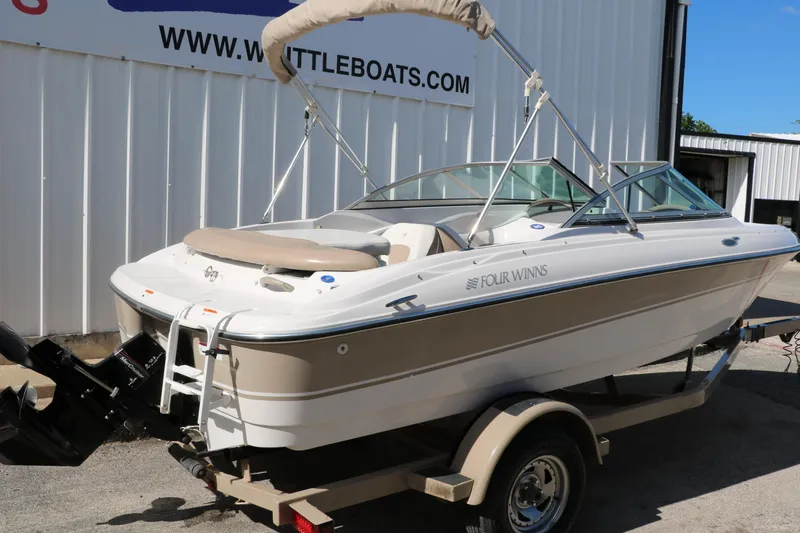 Slide: The Image of 2006 Four Winns 180 Horizon boat on trailer, parked outside a building. - 3