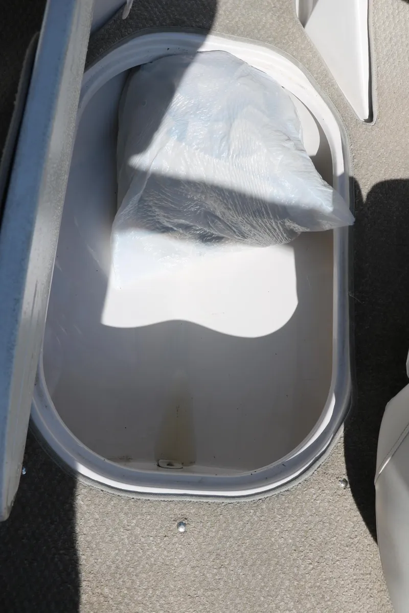 Slide: The Image of Storage compartment in a 2006 Four Winns 180 Horizon boat, containing a wrapped item. - 31