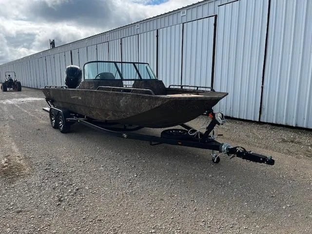 Slide: The Image of 2025 G3 Sportsman 2400 boat on trailer, parked outdoors near a large metal building. - 1