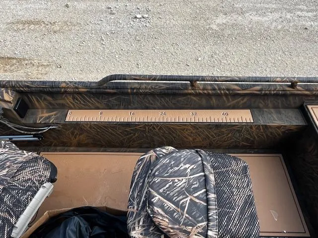 Slide: The Image of 2025 G3 Sportsman 2400 boat interior with camouflage seats and built-in measuring ruler. - 14