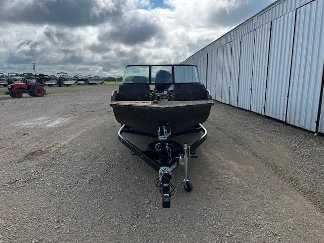 Slide: The Image of 2025 G3 Sportsman 2400 boat on trailer, parked outdoors near storage units. - 2