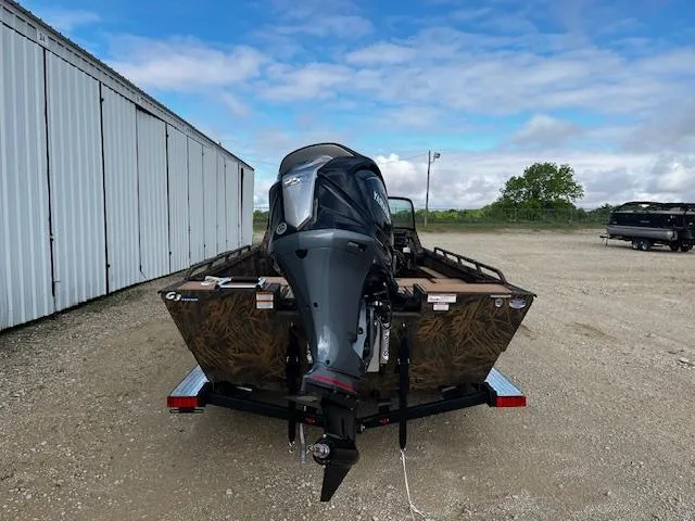 Slide: The Image of 2025 G3 Sportsman 2400 boat with outboard motor, parked outdoors on gravel. - 6