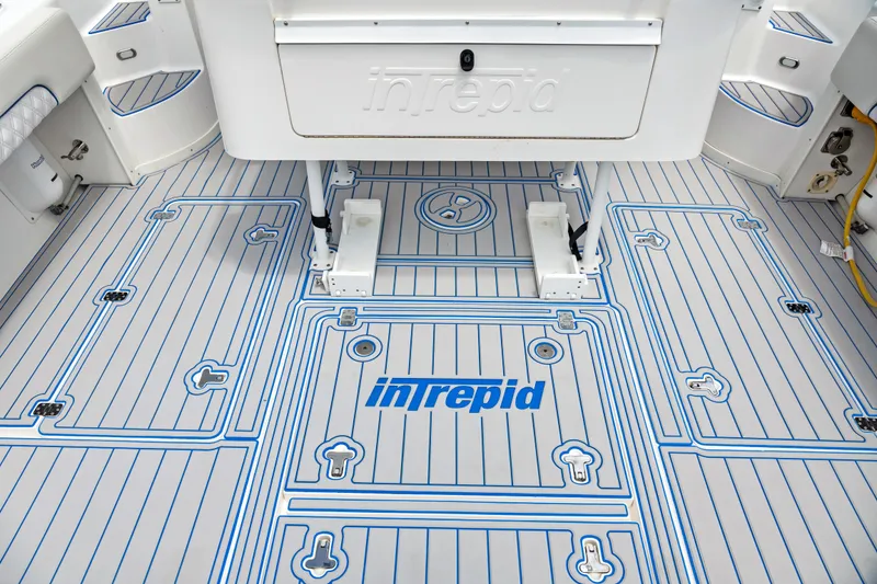 Slide: The Image of 2004 Intrepid 377 Walkaround boat deck with logo and storage compartments. - 16