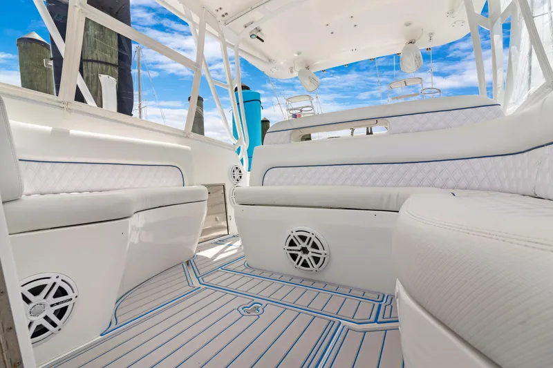Slide: The Image of 2004 Intrepid 377 Walkaround boat interior with white seating and blue accents. - 18