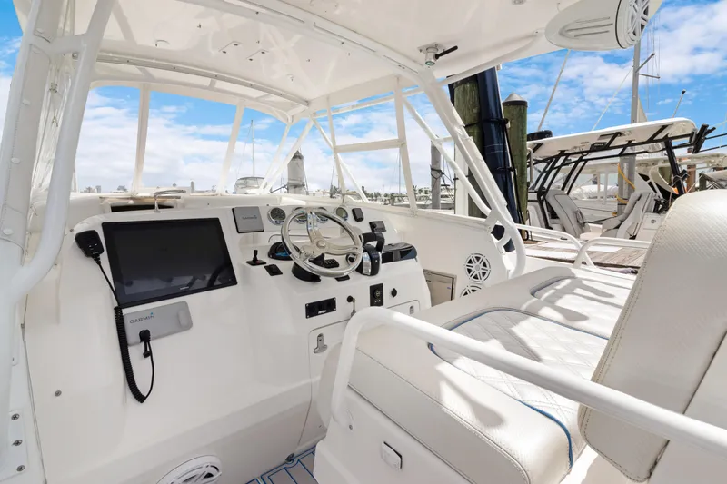Slide: The Image of 2004 Intrepid 377 Walkaround boat cockpit with steering wheel and navigation equipment. - 2