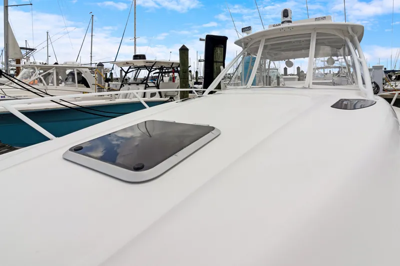 Slide: The Image of 2004 Intrepid 377 Walkaround boat docked at marina under blue sky. - 25