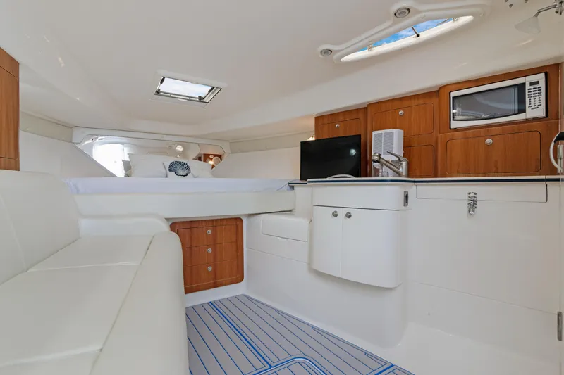 Slide: The Image of Interior of 2004 Intrepid 377 Walkaround boat with kitchenette and seating area. - 28