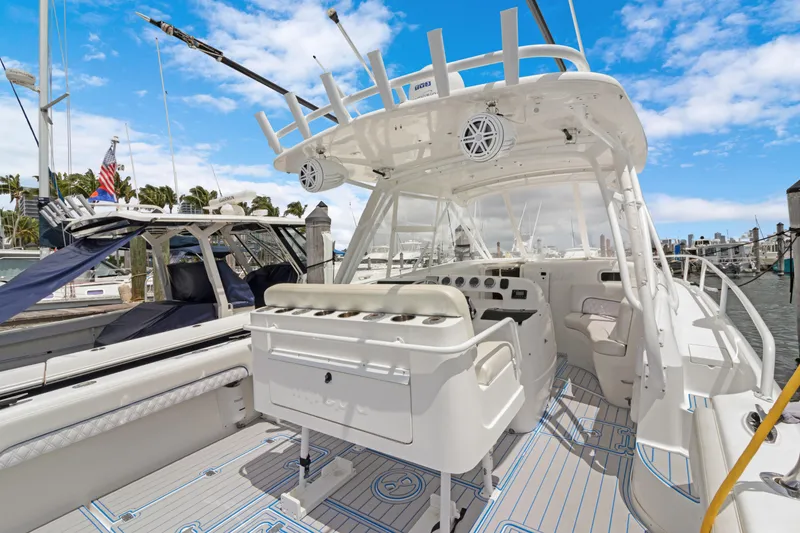 Slide: The Image of 2004 Intrepid 377 Walkaround boat with spacious deck and helm, docked under clear blue skies. - 45