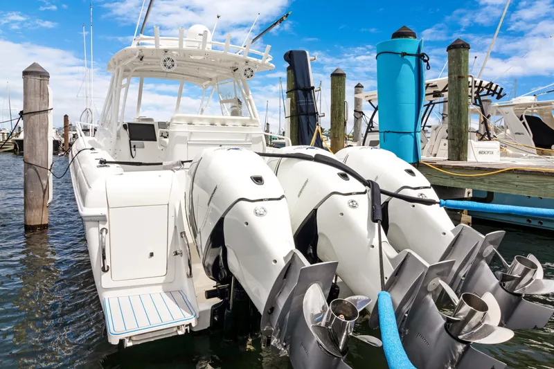Slide: The Image of 2004 Intrepid 377 Walkaround boat with triple outboard engines docked at marina. - 48