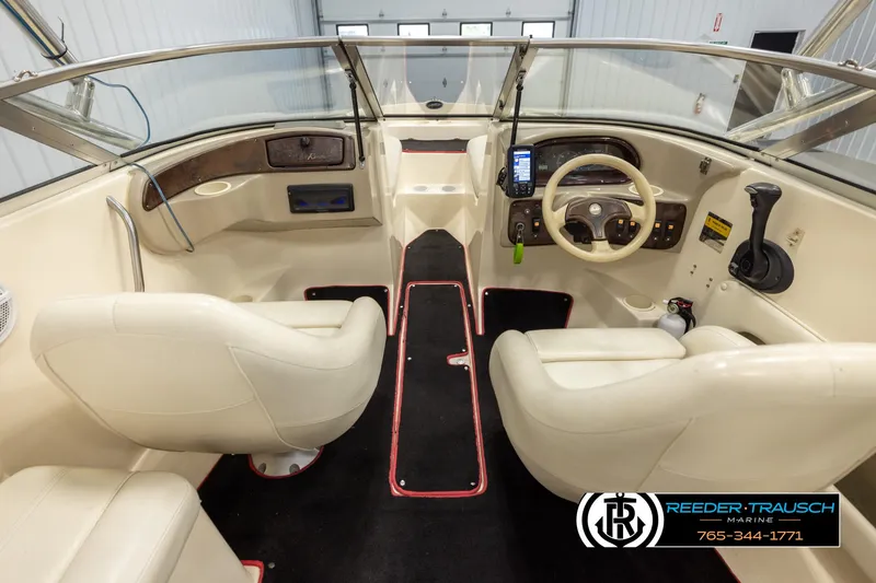 Slide: The Image of Interior of a 2002 Rinker 192 Captiva boat with beige seating and steering console. - 14