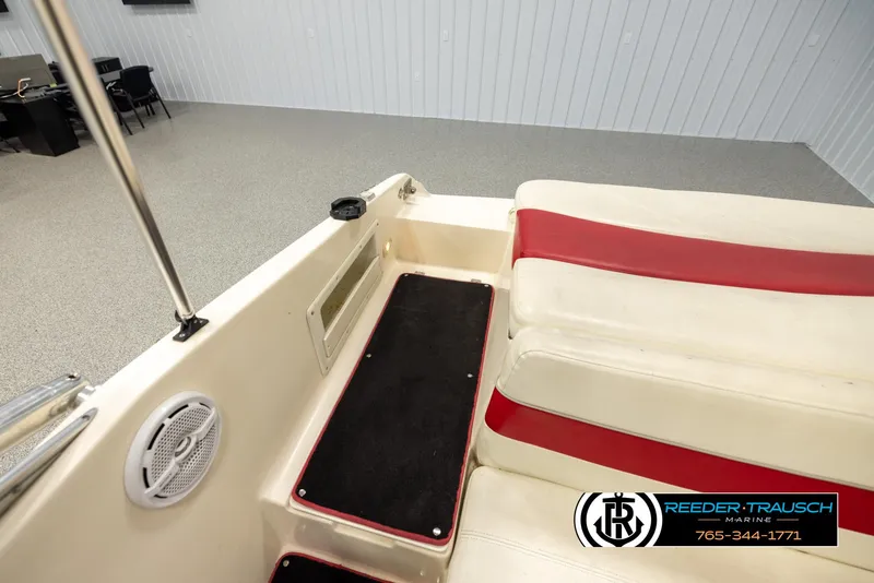 Slide: The Image of 2002 Rinker 192 Captiva boat interior with red and white seating, speaker, and carpeted step. - 28