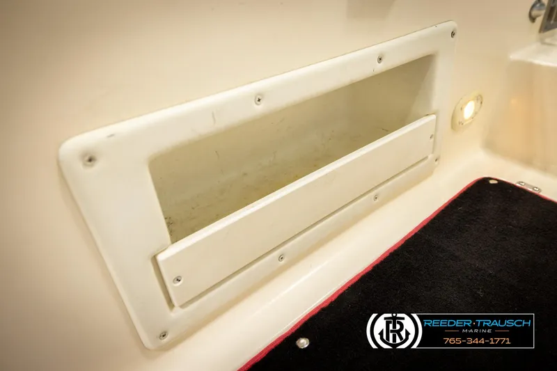 Slide: The Image of 2002 Rinker 192 Captiva boat interior storage compartment with logo and contact details. - 45