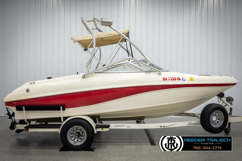 Slide: The Image of 2002 Rinker 192 Captiva boat on trailer, white with red stripe, indoor setting. - 5